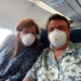 a man and woman wearing masks on an airplane