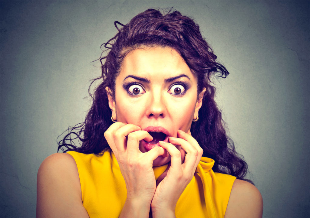 Scared shocked woman isolated on gray background - Eye of the Flyer