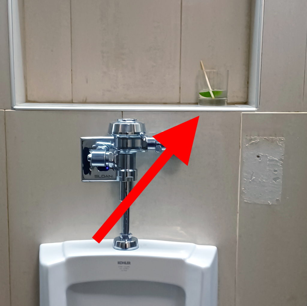 a urinal with a red arrow pointing to the top