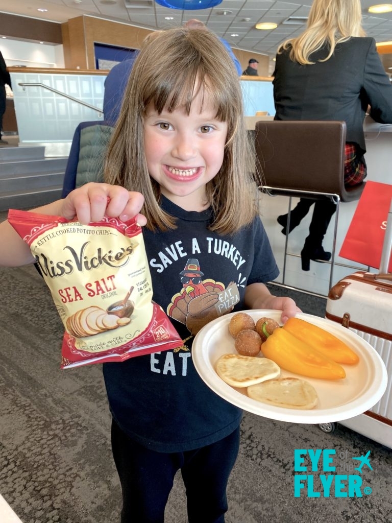 A young girl poses with snacks at the Delta Sky Club (F/G location) at the Minneapolis-St. Paul International Airport (MSP).