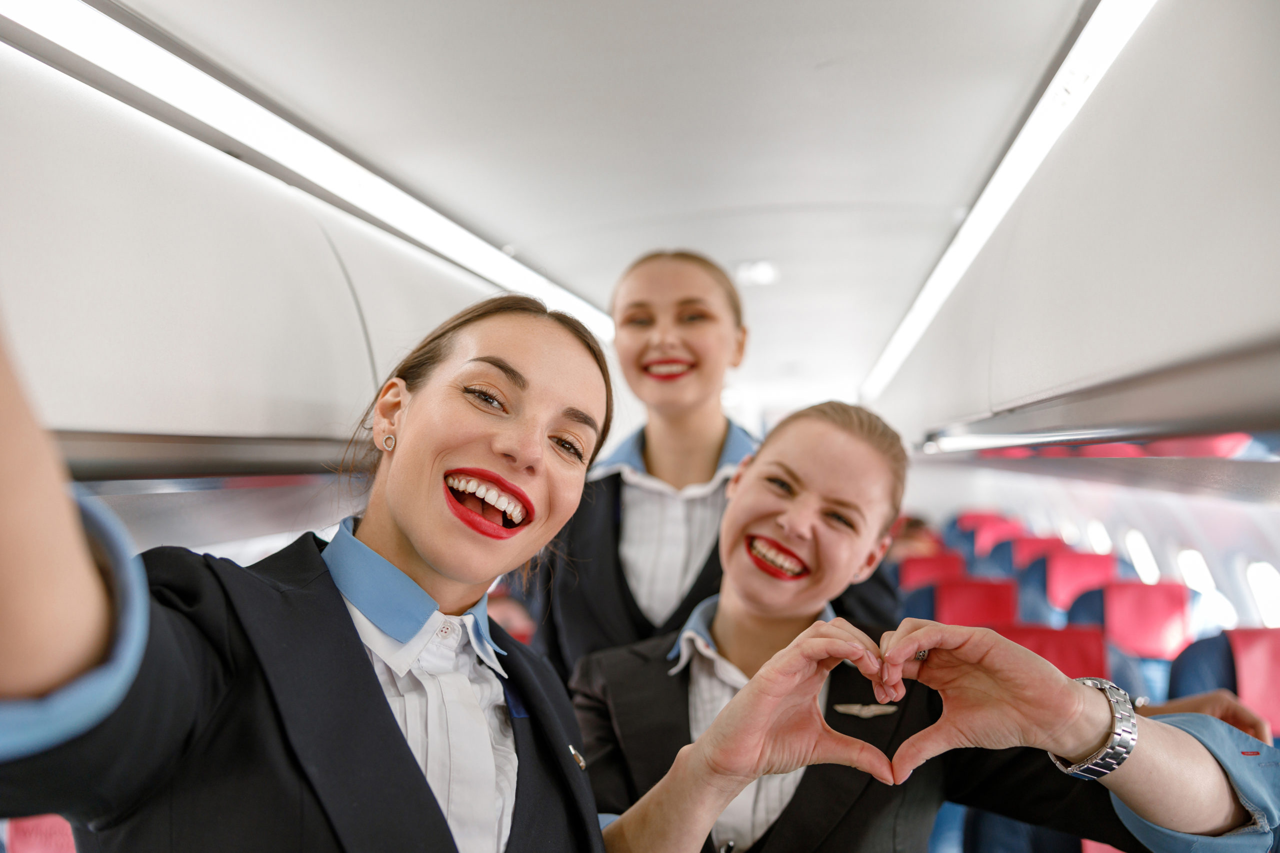 Premium Photo | Attractive female air hostess in bright blue uniform  smiling at camera while leading trolley cart with gifts, souvenirs through  empty plane aisle. travel, service, transportation, airplane concept