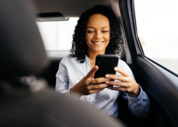 Businesswoman using smartphone in the car
