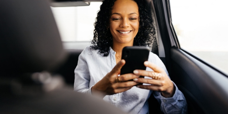 Businesswoman using smartphone in the car