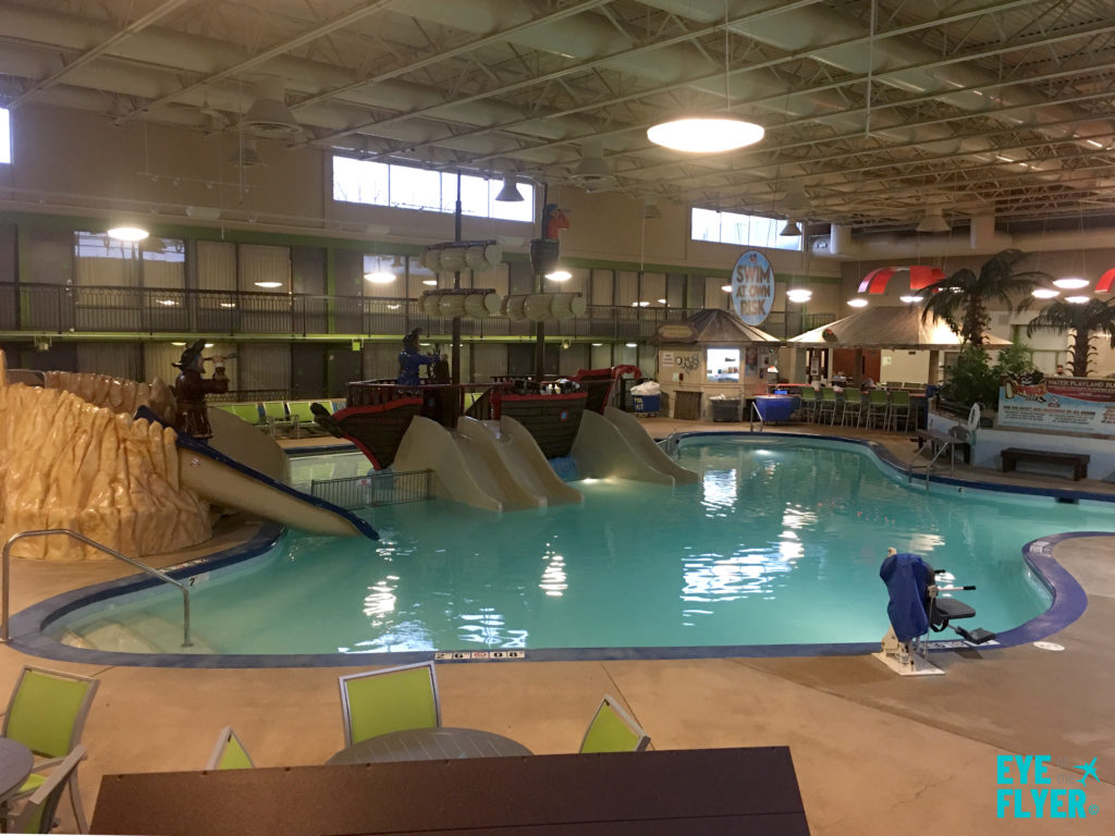 a indoor pool with slides and people in it