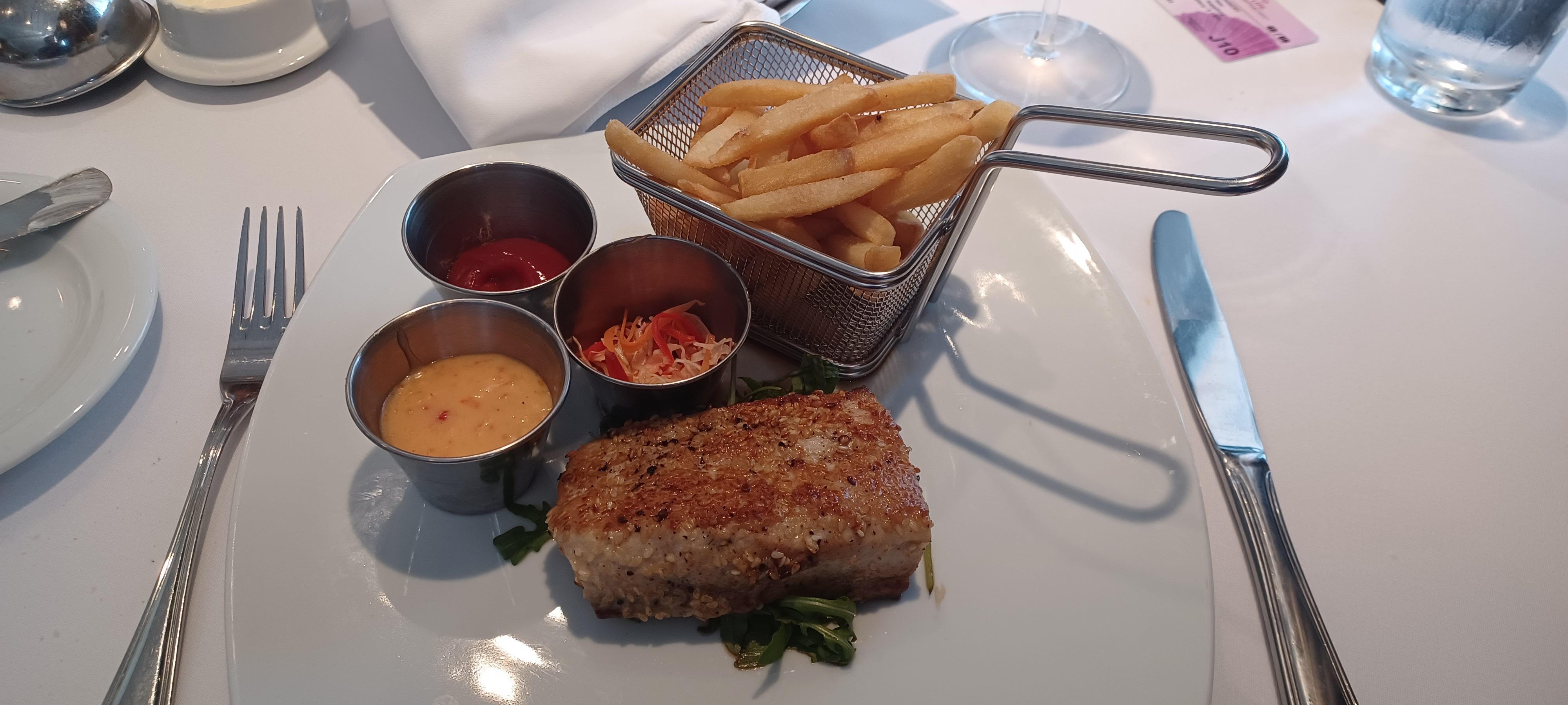 a plate of food with a basket of sauces and a fork