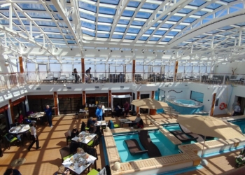 a large indoor pool with people sitting around it
