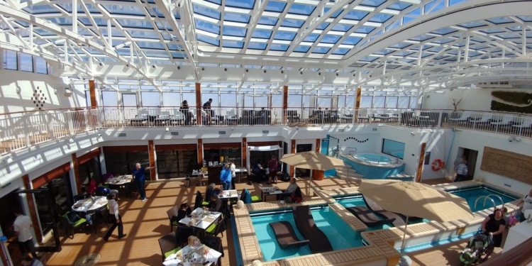 a large indoor pool with people sitting around it