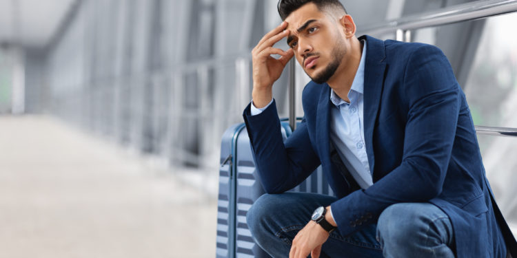 A nervous, anxious traveler at an airport. Flight delay.