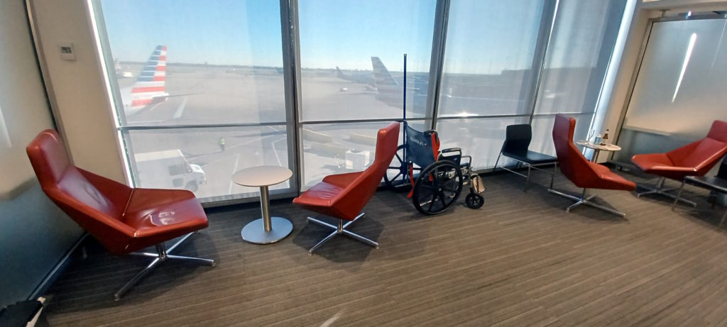 a wheelchair and chairs in a room with windows
