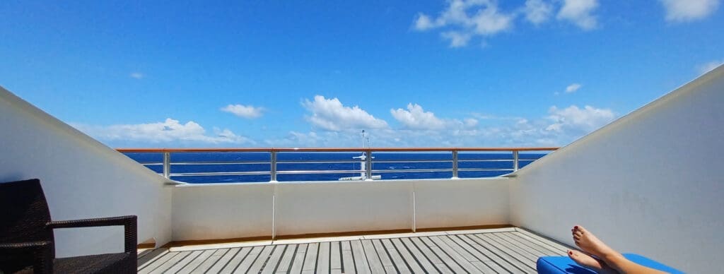 a deck with a railing overlooking the ocean