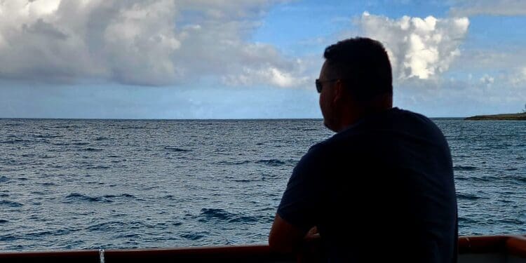 a man standing on a boat looking out over the ocean