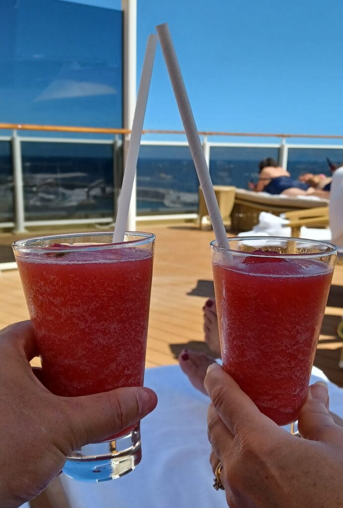 a pair of hands holding drinks with straws