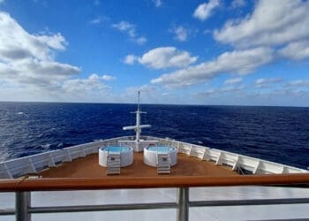 a deck of a ship with a tub on the water