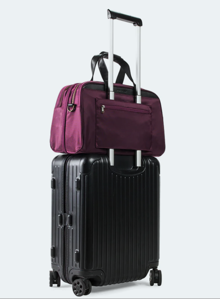 a black suitcase with a purple bag on top