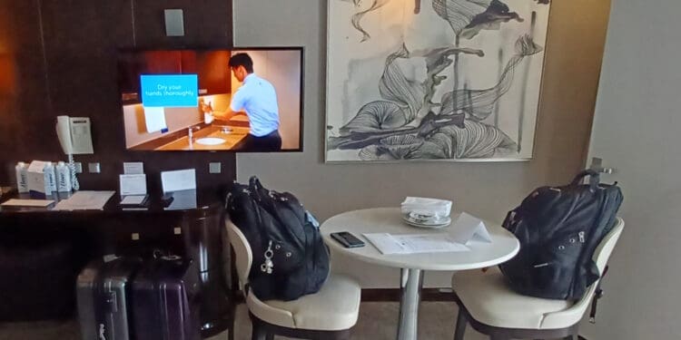 a room with a television and chairs and a table