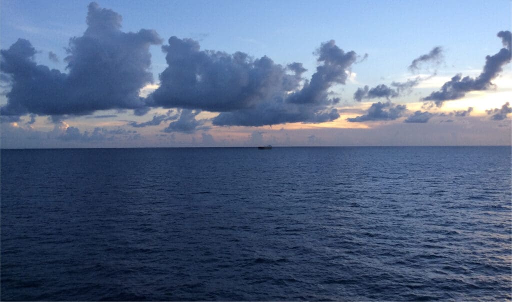 a large body of water with a boat in the distance