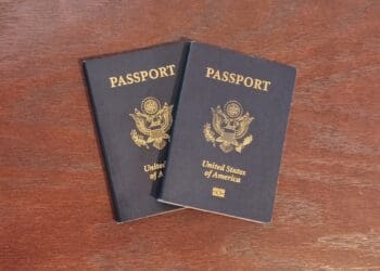 two blue passports on a wooden surface