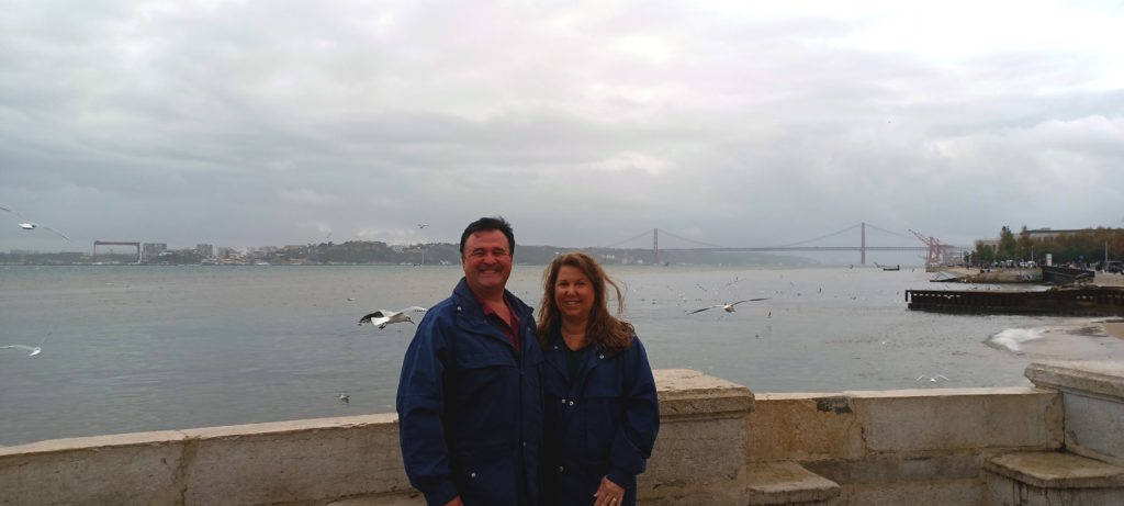 a man and woman standing in front of a body of water
