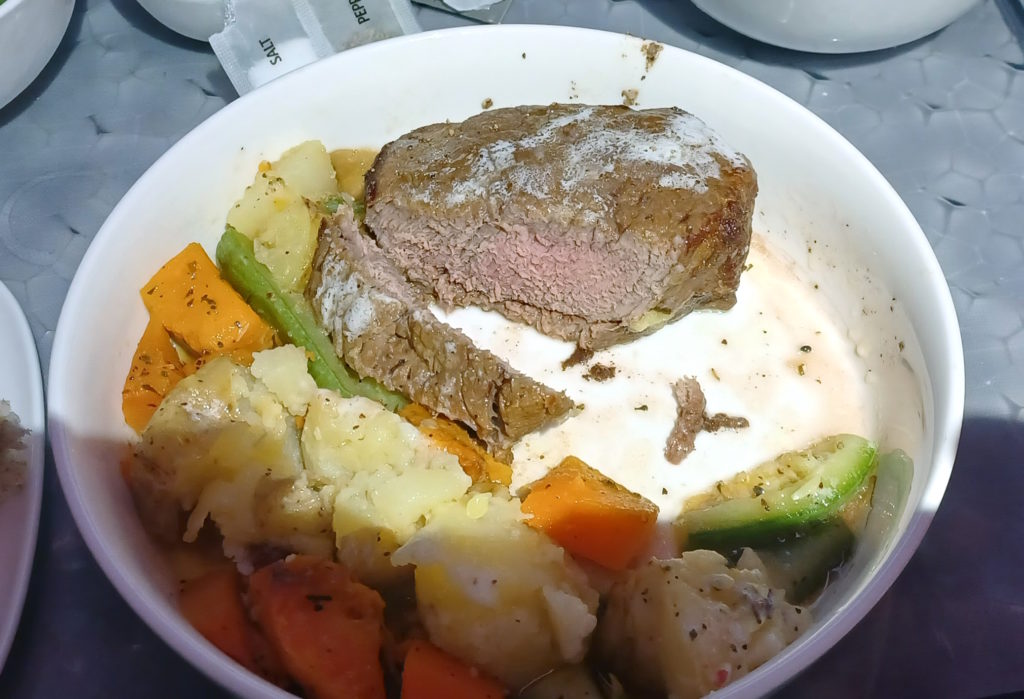 a bowl of food with meat and vegetables