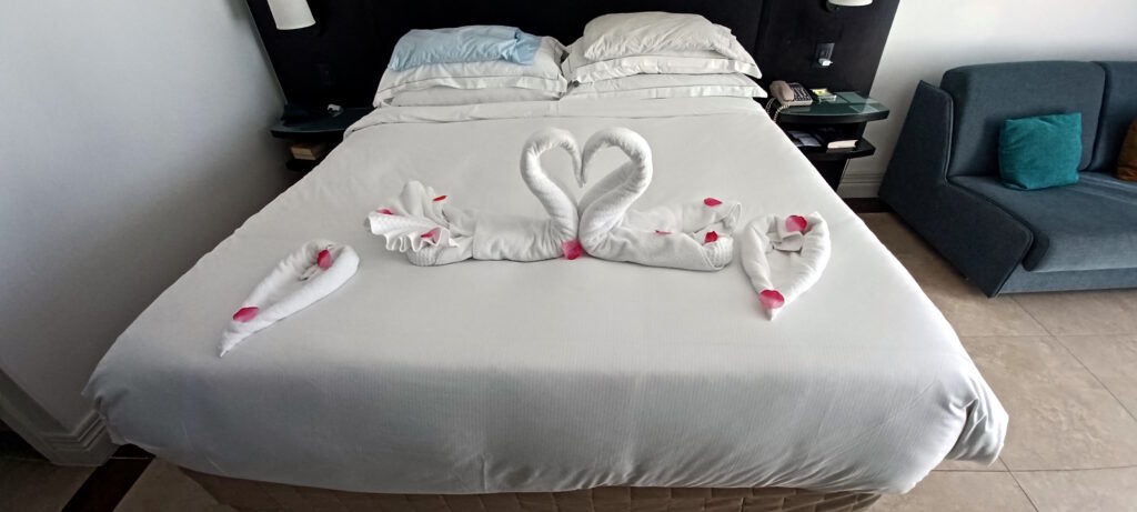 a bed with towels made of swans