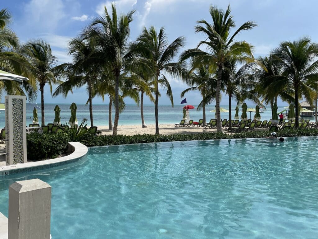 a pool with palm trees and a beach