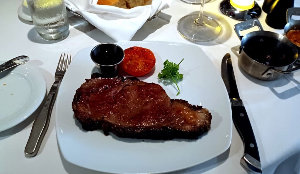 a plate of steak and tomato