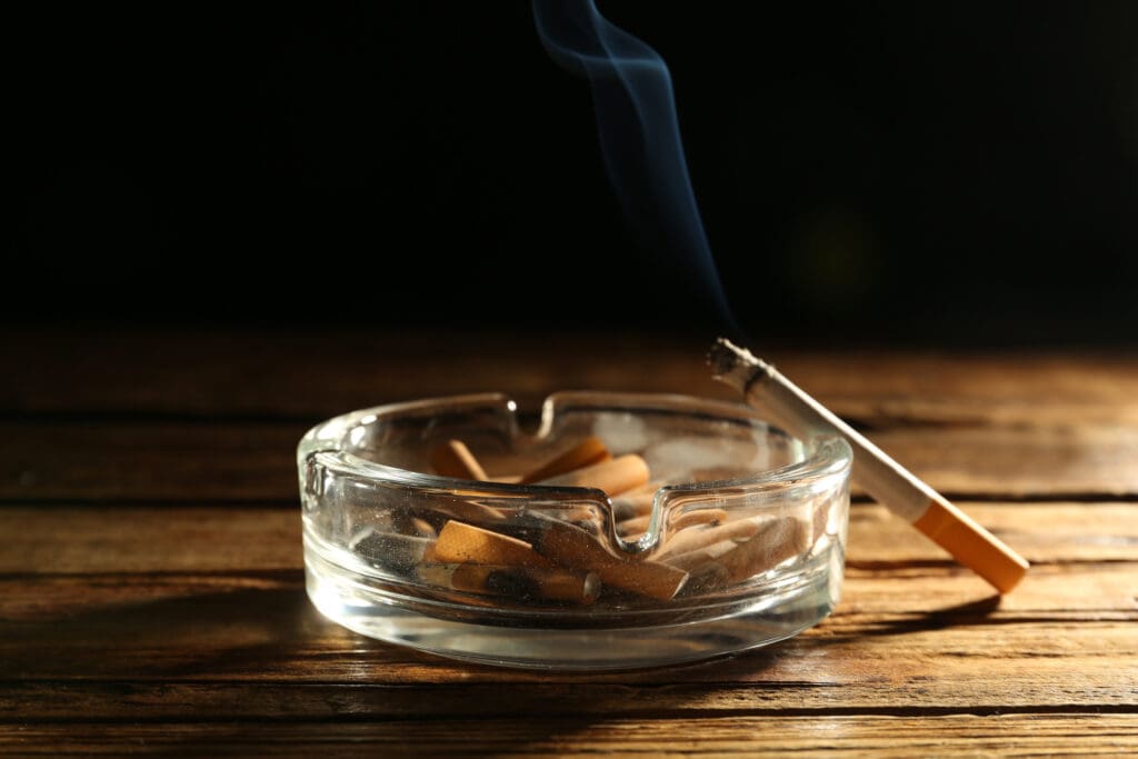 Cigarette smoking with butts in ashtray