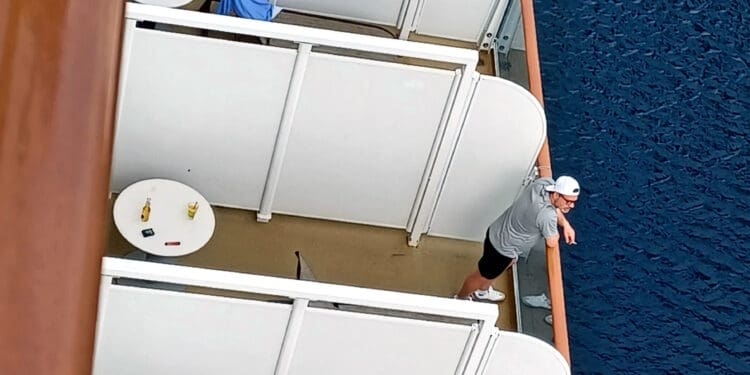 a man standing on a balcony overlooking a body of water