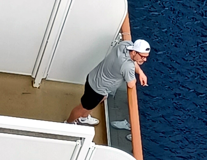 a man standing on a deck with a cigarette