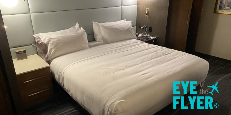 a bed with white sheets and a lamp