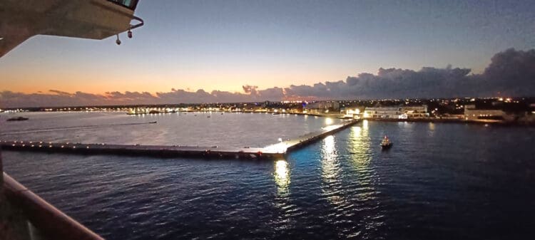 a dock with lights on it and a city in the background