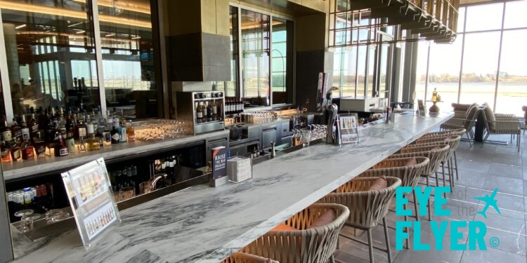 a bar with chairs and a large window