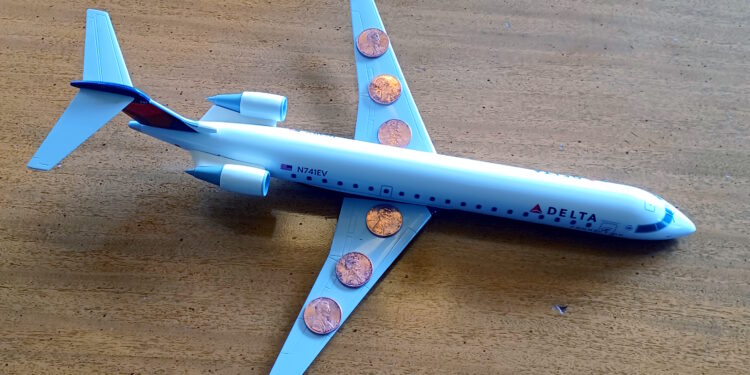 a toy airplane with a few coins on it