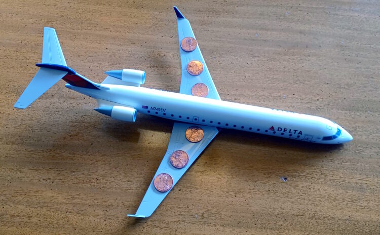 a toy airplane with a few coins on it