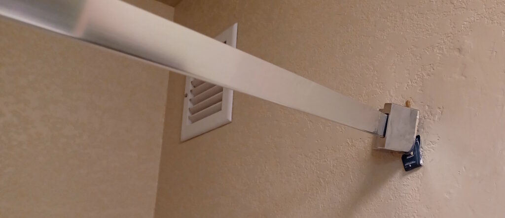 a white metal bar above a vent