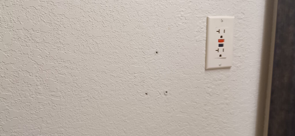 a white wall with holes in it