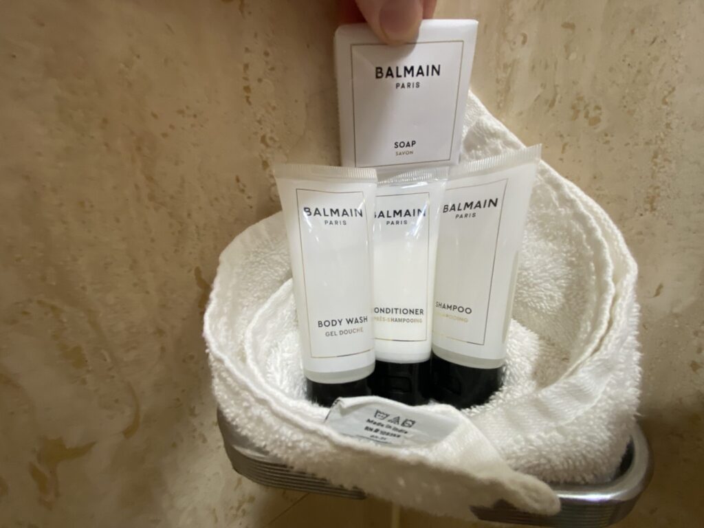 a hand holding a small white package of toiletries