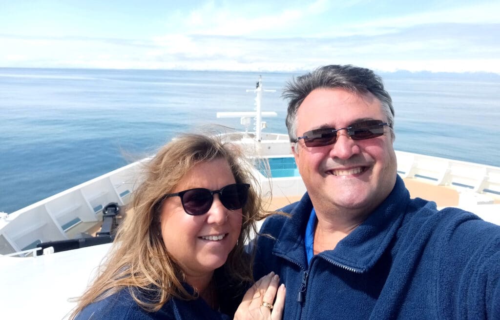 a man and woman taking a selfie on a boat