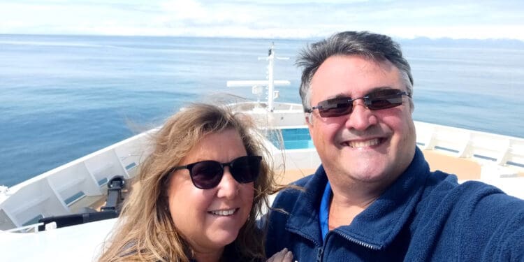 a man and woman taking a selfie on a boat