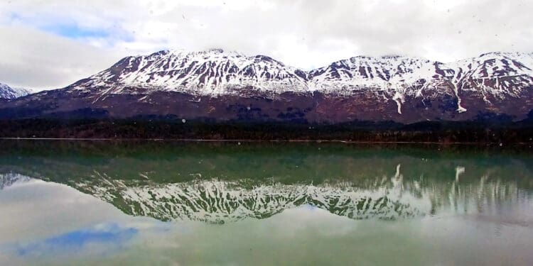 a lake with snow covered mountains in the background