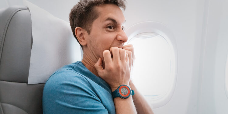 Anxious, nervous airline passenger sitting at a window seat