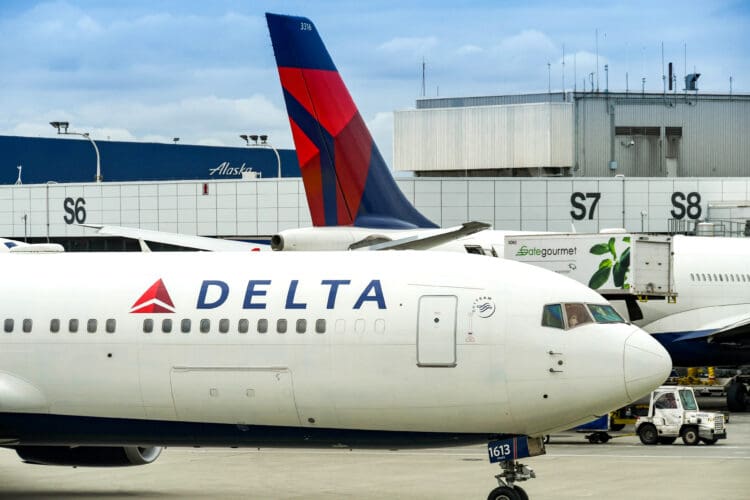 a white airplane with red and blue tail fin