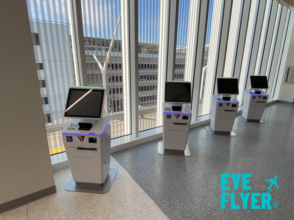 a row of white kiosks with screens in front of a window