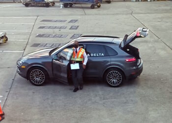 a man standing in a car with the door open