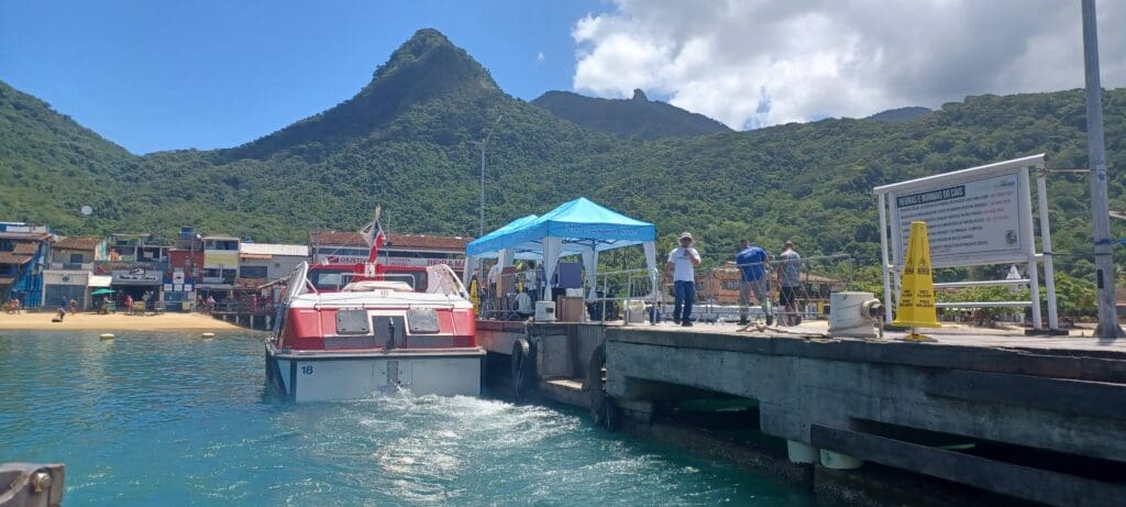 a group of people on a dock with a blue tent