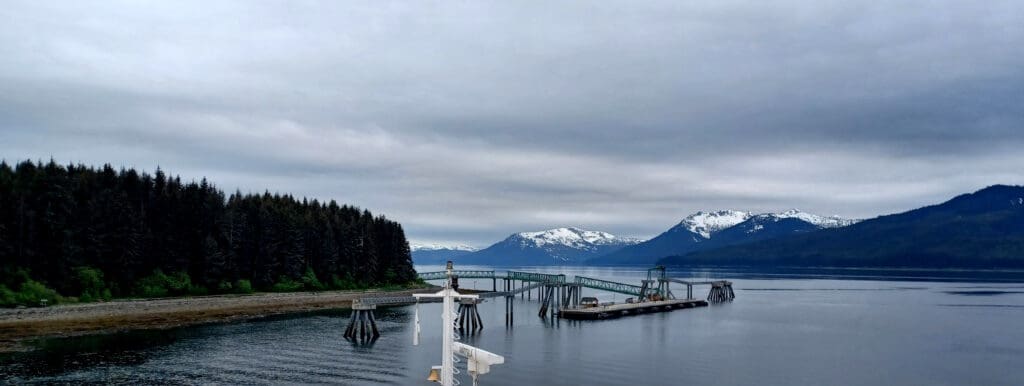 a bridge over water with mountains in the background