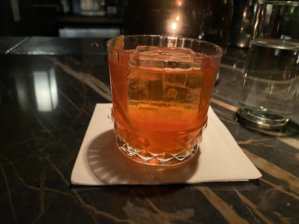 a glass with a drink on a napkin