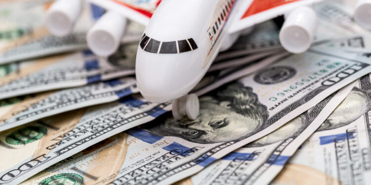 An airplane posed on top of money