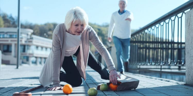 a woman kneeling on the ground with fruit on the ground