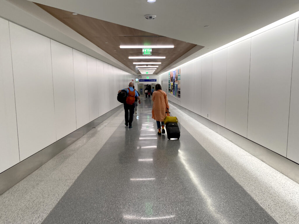 people walking in a hallway with luggage